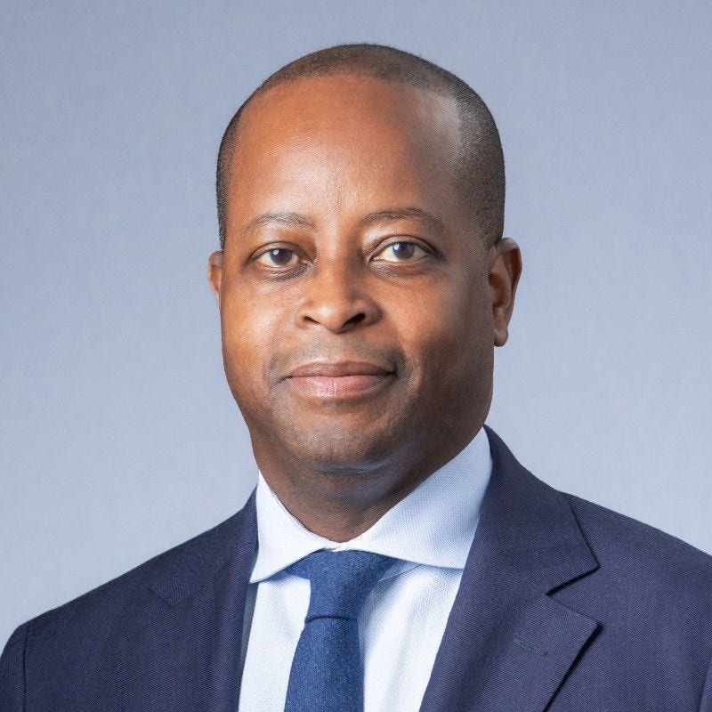 Professional headshot of a man in a navy suit and tie