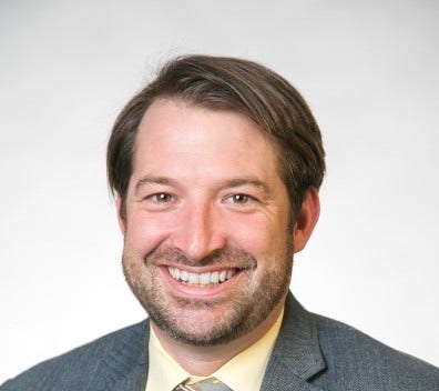 white man with brown hair and closely trimmed beard and moustache